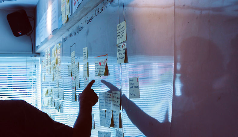 Person pointing to a bad with post it notes