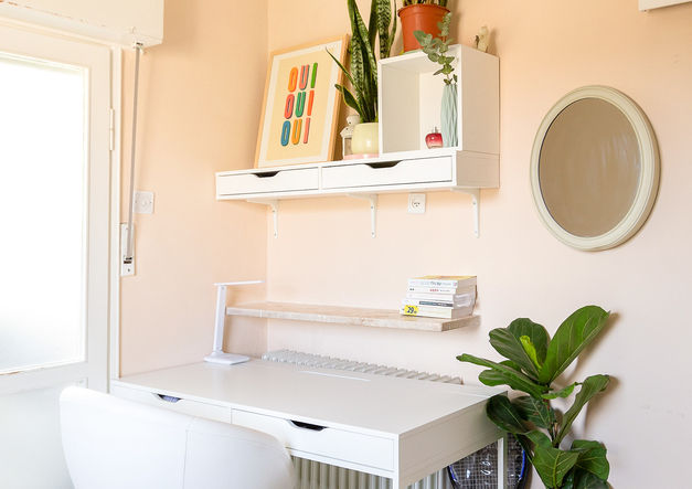 ein weißer Schreibtisch mit einem Stuhl und einem Regal mit einem Poster mit der Aufschrift „oui oui oui“