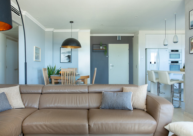 ein Wohnzimmer mit einer braunen Ledercouch und Kissen