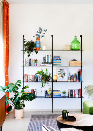 ein Bücherregal voller Bücher und Pflanzen hat eine Kiste auf dem untersten Regal, auf der " IKEA " steht