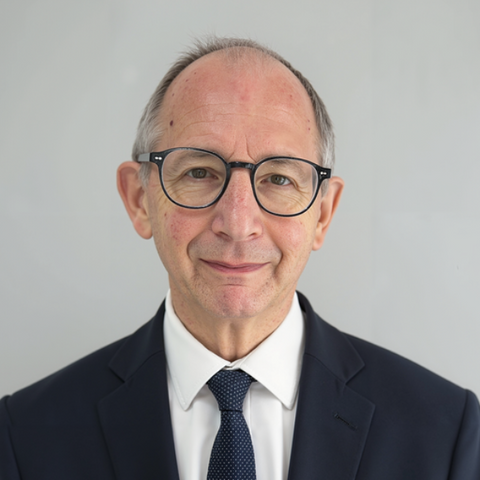 Man in a dark suit and glasses