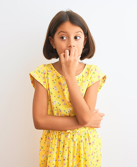 Young beautiful child girl wearing yellow floral dress standing over isolated white backgr