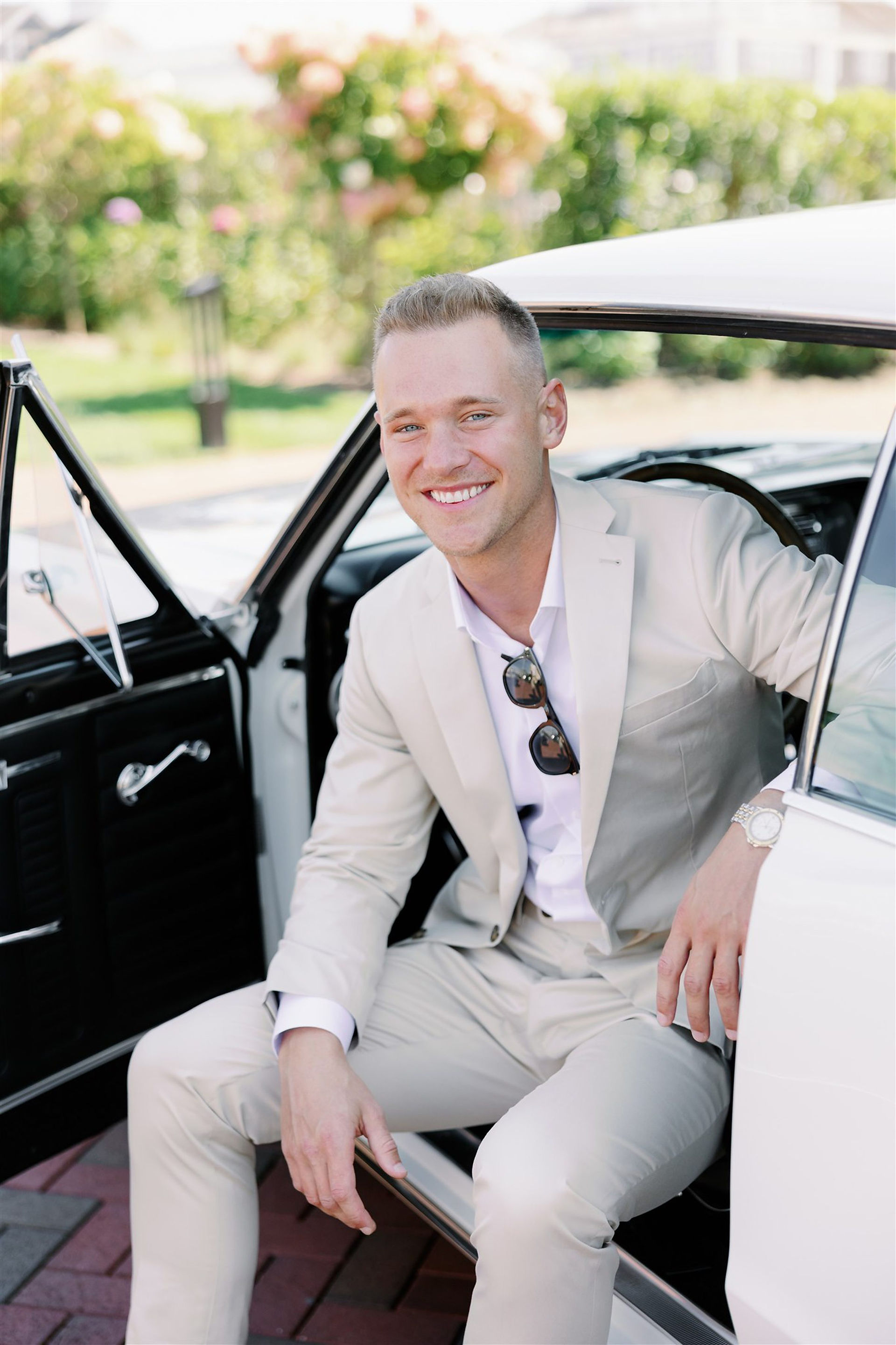 Groom portrait sitting in vintage car