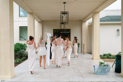 Candid photo of bride and bridesmaids walking into venue