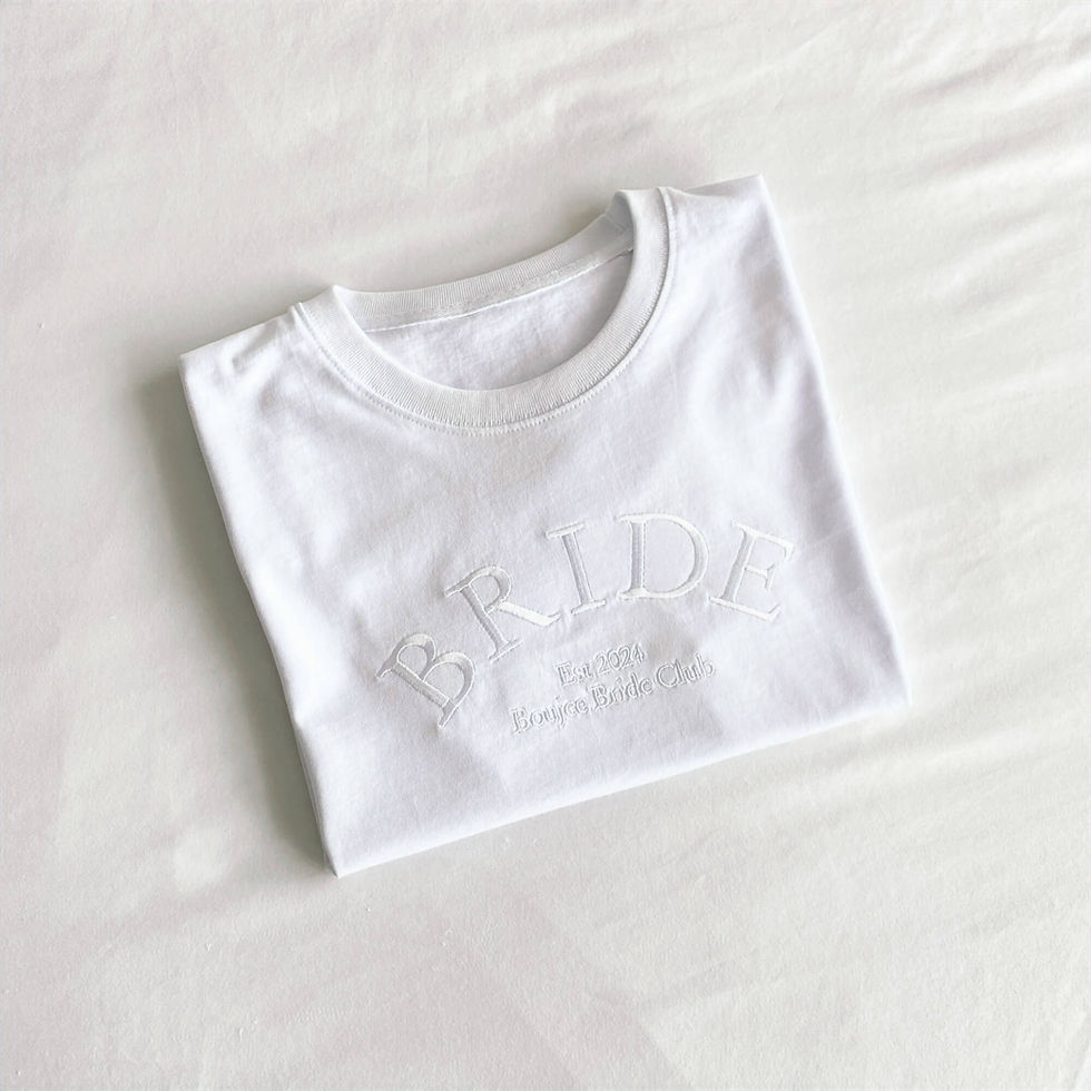 Thumbnail: White t-shirt with a large white embroidered design across the chest which reads "BRIDE"