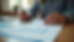 Eye-level view of a person reviewing health insurance documents at a kitchen table