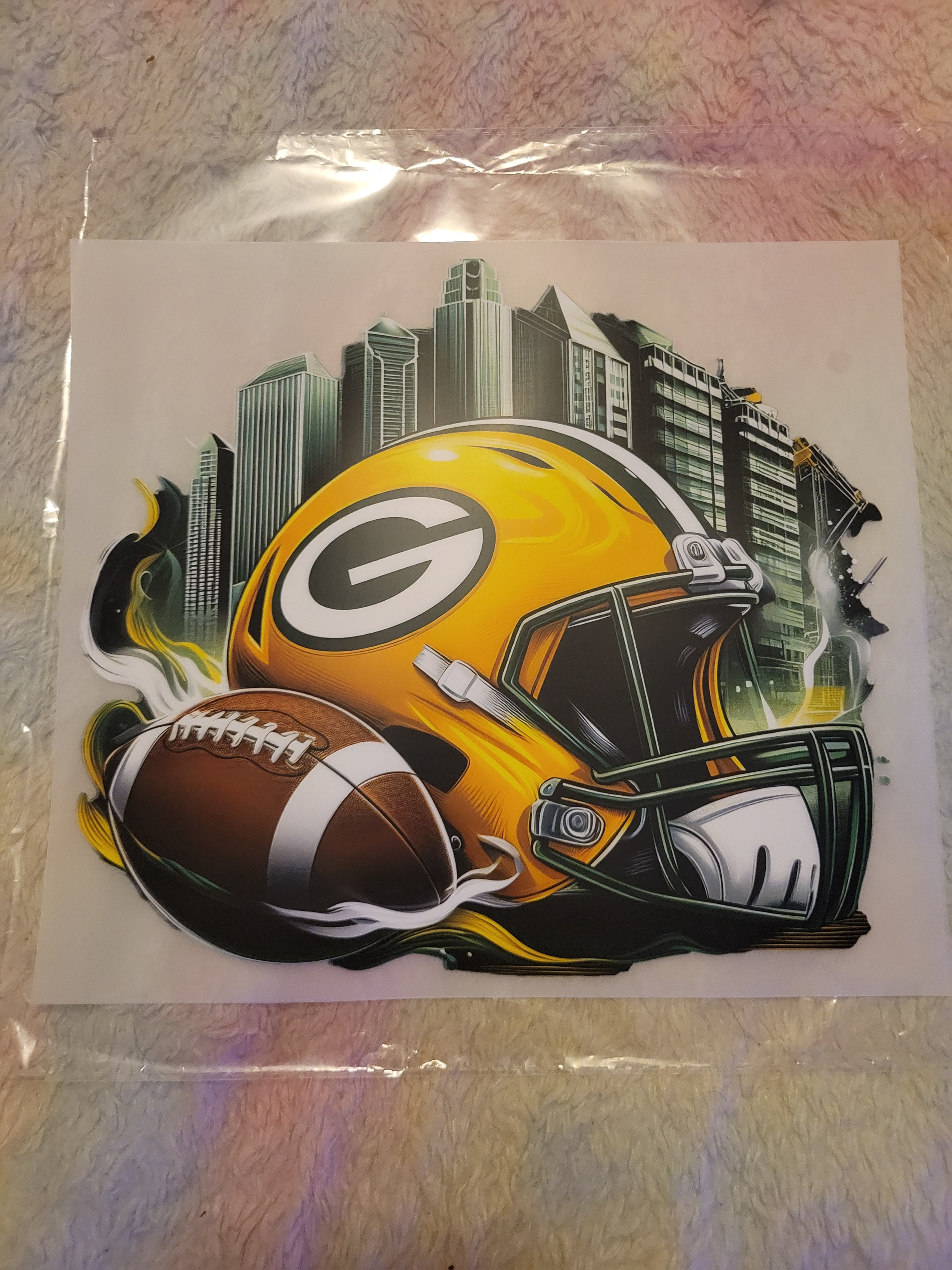 Green Bay Packers helmet, football, and city skyline