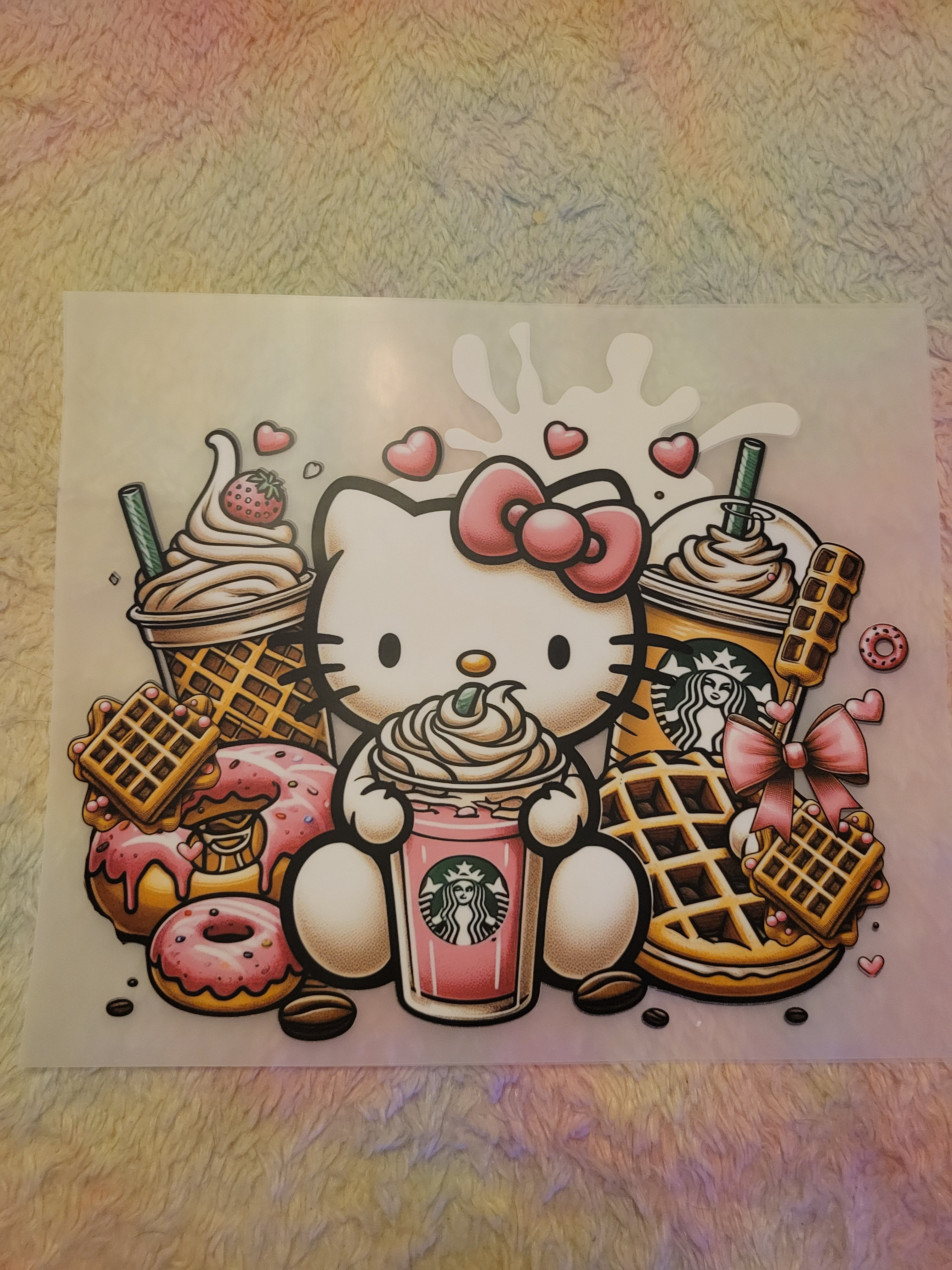 Hello Kitty with a Starbucks drink, surrounded by donuts and sweets