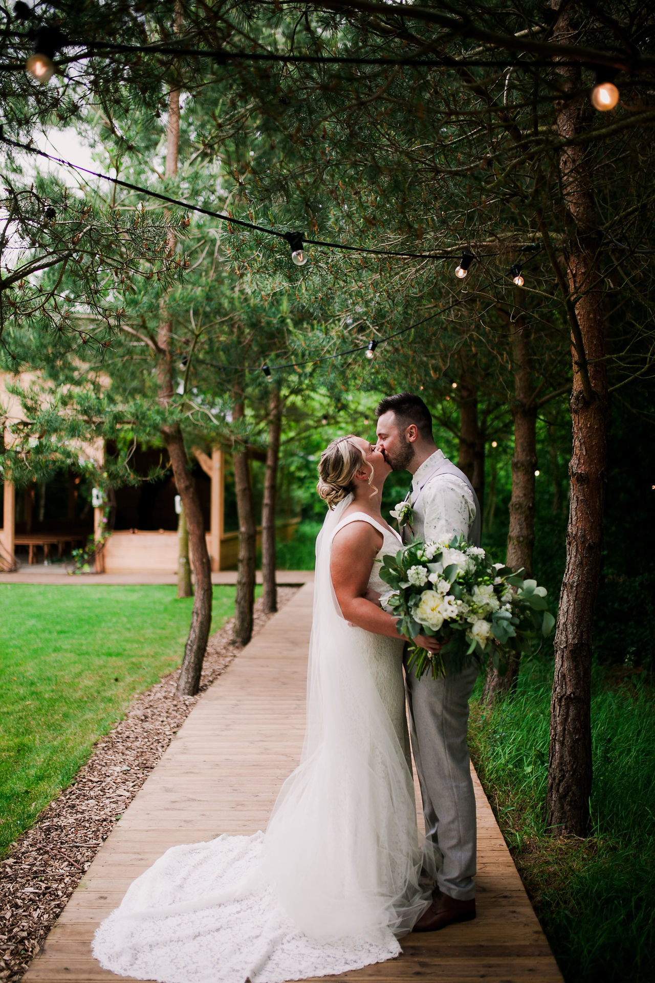 Bride and groom posing among trees at Bradbury Glade