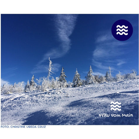 Blauer Himmel mit aufsteigenden Schleierwolken über schneebedeckter Berglandschaft