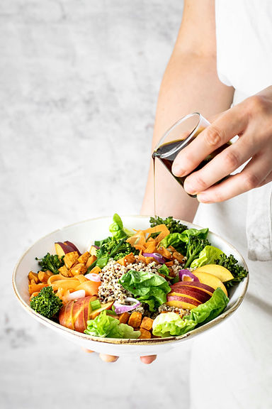 woman-pouring-pumpkin-seed-oil-sweet-potato-buddha-bowl.jpg