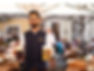 Servicekraft im Augustiner serviert mit einem Lächeln zwei Bier