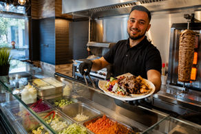 Lächelnder Koch mit frischem Döner