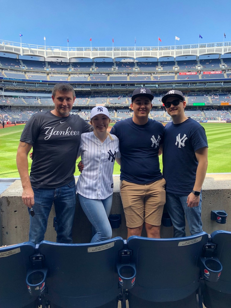 Alex with her father and brothers at a Yankees Game in New York City