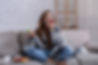 Sad young lady coping with depression or stress by eating sweets on sofa at home. Unhappy