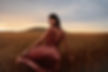 Young woman feeling happy in field of wheat crop at sunset. Female enjoying a day in natur
