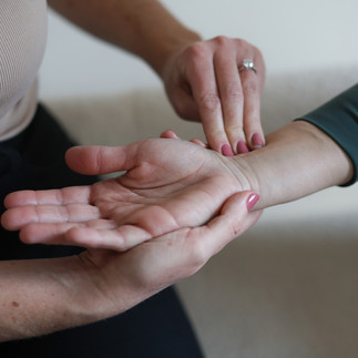 An acupuncturist is performing a pulse diagnosis on a patients wrist