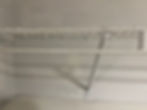 White wire closet shelf with hanging rod and support bracket