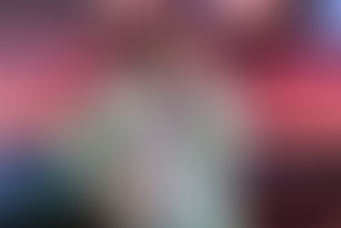 Missy Elliot performing on stage at Essence Festival wearing colorful outfit and holding microphone