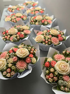 Oblong wedding cupcake arrangements with realistic floral designs perfect for rectangular reception tables