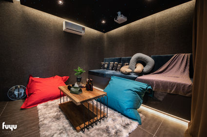 Cozy home theatre room in Johor Bahru with dark acoustic walls and bean bag seating by Fuyu Dezain

