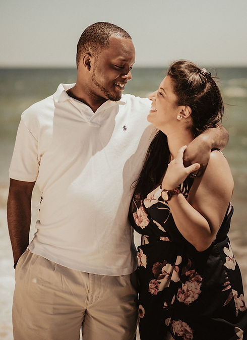 man in white polo shirt kissing woman in black and pink floral dress