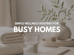 Quantum.Silver® Human Care products styled on a warm neutral bathroom counter with folded towels, soap, deodorants, shampoo and natural décor.