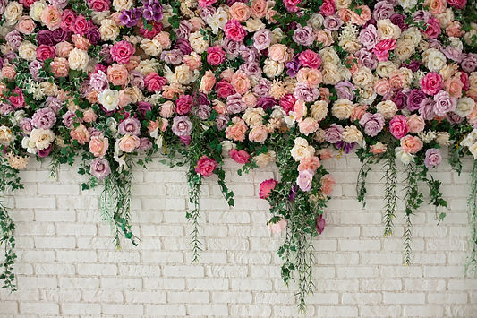 Wall with curly Flowers. Brick wall with beautiful flowers in room. Summer flowers on wall