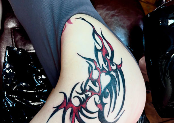 Tribal tattoo with bright red and black ink.