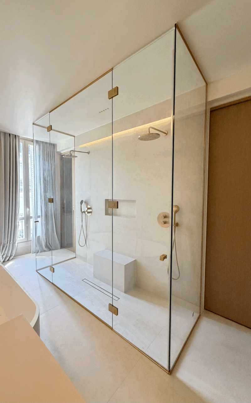 paroi de douche sans cadre en verre trempé avec finitions dorées Paris