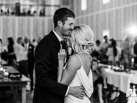 Black and white photo of bride and groom dancing and laughing in each other’s arms, captured by Minnesota wedding photographer.