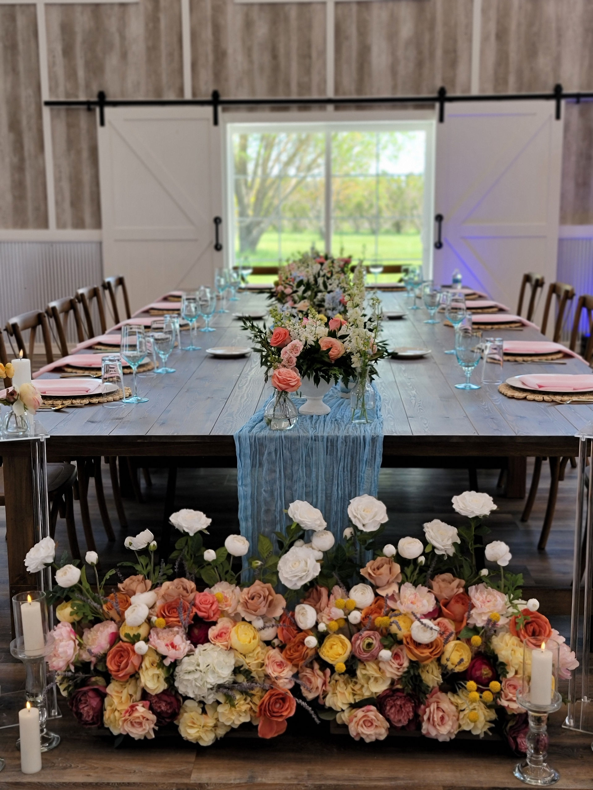 Wedding venue near Windom, MN, harvest style head table filled with fresh spring colored flowers.