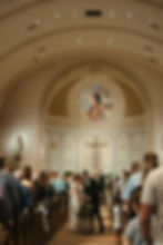 Bride and groom share a kiss in the aisle of a stunning church, a timeless moment documented by a Brookings SD wedding photographer.