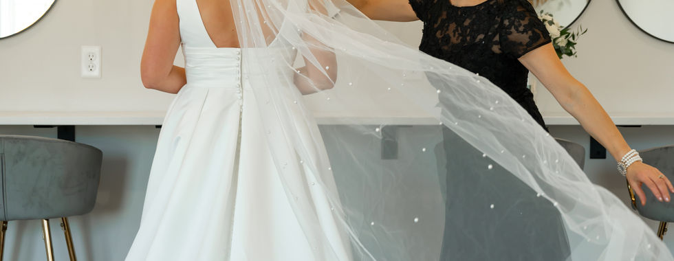 A touching moment as the bride’s mother adjusts her veil in the naturally lit bridal suite at 5 Family Ranch. Captured by Brittany Maasch Photography, a South Dakota and Minnesota wedding photographer.