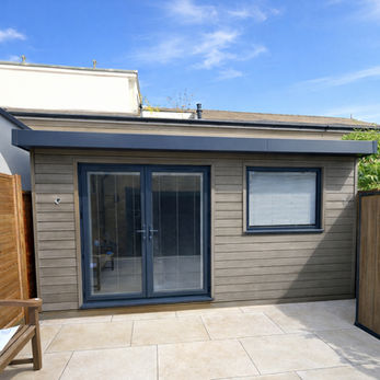 Small garden studio with sliding doors and modern cladding
