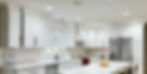 A modern kitchen featuring white cabinets and a central island, refaced by Ideal Cabinet Refacing.