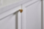 Detail of shaker style kitchen cupboard joinery doors and brushed gold handles.