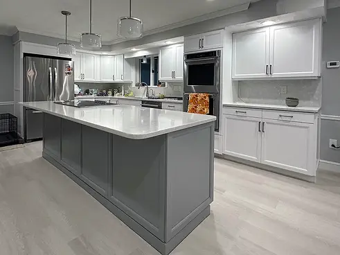 Modern kitchen featuring a large island and a refrigerator, showcasing updated cabinetry in North Andover, MA.