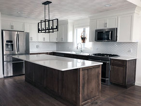 Refaced white upper cabinets and rustic base and island cabinets in a kitchen with white cabinets and wood floors.