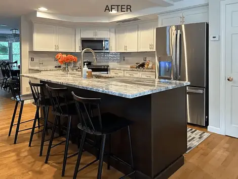 Refaced kitchen in Westford, MA, showcasing white cabinetry, a dark island, and a spacious refrigerator.