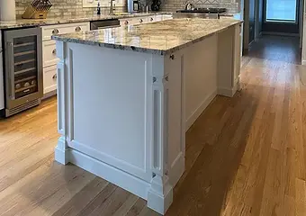 Spacious kitchen with a custom-built island by Ideal Home Improvement and elegant white cabinetry.