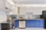 Modern kitchen with blue cabinets and white appliances, recently remodeled with cabinet refinishing for a fresh look.