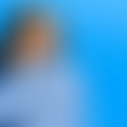 Idosa sorrindo enquanto ajusta um aparelho auditivo no ouvido