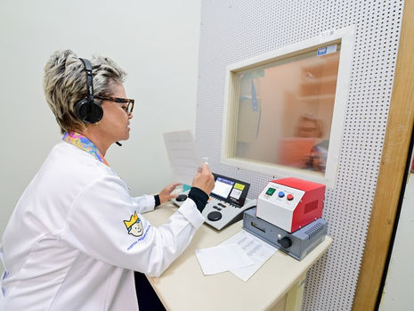 Criança em atendimento de saúde pediátrica em matéria sobre TDAH, investigação otorrinolaringológica, sono, audição e aprendizagem infantil.