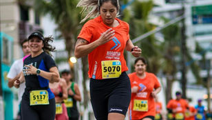 Mulheres correndo em prova de rua com cenário urbano e clima esportivo