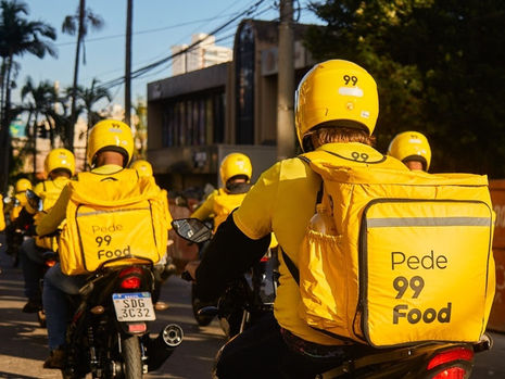 Entregador da 99Food com mochila amarela realizando entrega de comida em Salvador.