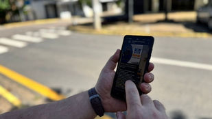 Pessoa utilizando celular com WhatsApp para recarregar créditos de transporte público via Pix