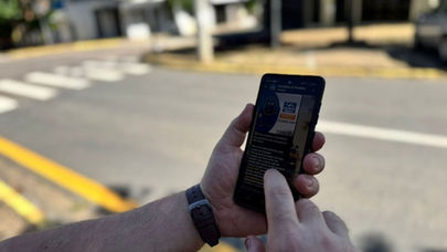 Pessoa utilizando celular com WhatsApp para recarregar créditos de transporte público via Pix