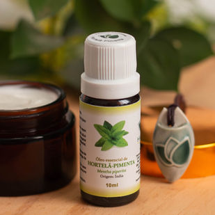 Difusor de aromaterapia com óleos essenciais sobre mesa de trabalho, auxiliando na concentração e bem-estar.