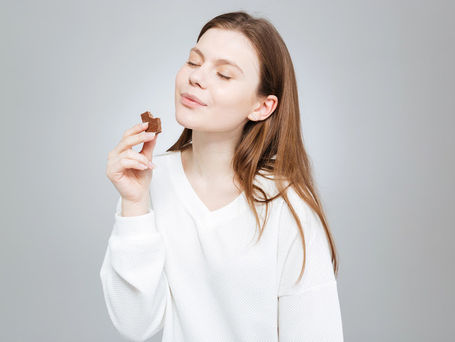 Médica otorrinolaringologista segurando um modelo anatômico de ouvido humano durante explicação sobre audição.